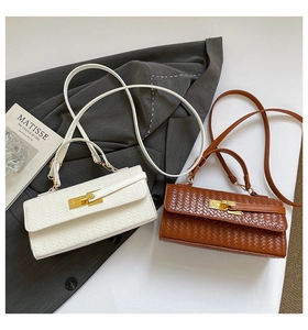 Detail view of woven leather texture and gold twist locks on white and brown flap bags