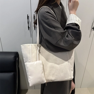 Grand sac cabas minimaliste blanc crème avec pochette porté par un mannequin pour le quotidien