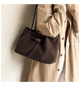 Close-up of deep brown faux suede tote bag featuring silver buckle detail and fine texture