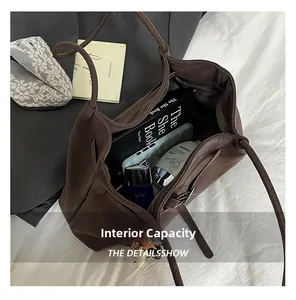 Top-down view of a spacious brown tote bag interior filled with everyday essentials