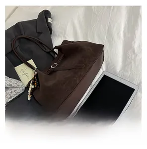 Deep brown suede tote bag with leather strap buckle and colorful beaded charm detail
