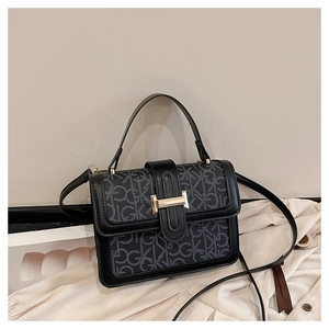 Close-up of black crossbody bag with logo pattern and golden H-shaped metal buckle