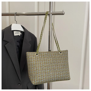 Detail of multi-color tweed texture and silver metal chain strap on a tote bag