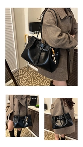 Detail of black leather tote bag with drawstring closure and wood bead charm accessory