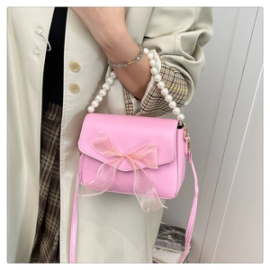 Pink pearl handle crossbody bag with a delicate tulle bow and glossy finish leather