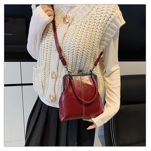 Detail of vintage burgundy doctor bag with metallic clasp and oil-wax leather texture