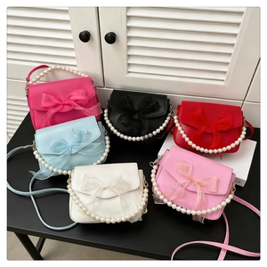 Group shot of colorful mini crossbody bags with large bows and pearl handles