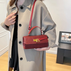 Deep red woven texture handbag with gold twist lock shown on a trench coat model
