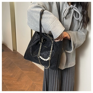 Detail of leopard print tote bag with golden chain and white pearl strand decorations