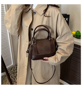 Detail der dunkelbraunen Umhängetasche kombiniert mit khakifarbenem Trenchcoat für Herbstlooks