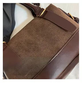 Details der Mischtextur aus mattem Wildleder und glattem Leder an der braunen Vintage-Tasche