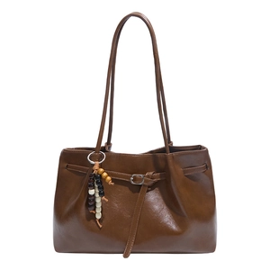 Retro brown leather tote bag with ethnic beaded charm and silver buckle detail