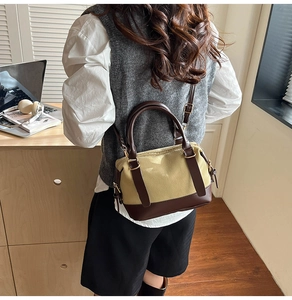 Close-up of a minimalist canvas and leather crossbody bag worn by a model in a casual setting