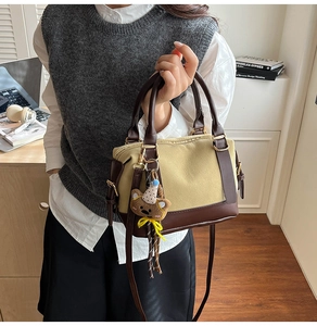 Close-up of minimalist canvas and leather crossbody bag with cute bear charm