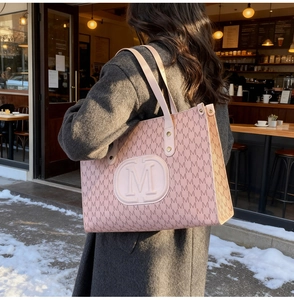 Pink and brown tote bag with M letter jacquard monogram pattern shown on woman shoulder