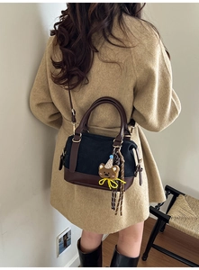 Détail du petit sac rétro carré avec bandoulière en cuir brun et pendentif ours mignon