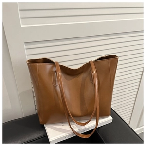Detailed view of caramel tote bag with vertical stitching and slim shoulder straps