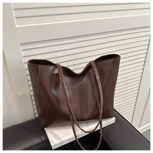 Detail of a dark brown minimalist tote bag with smooth texture on a white background