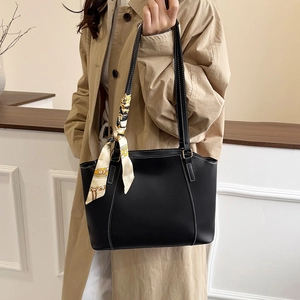 Minimalistische schwarze Leder-Shopper mit weißen Kontrastnähten und einem gemusterten Seidentuch