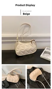 Detail view of beige faux leather shoulder bag with quilted triangle texture and metal zipper