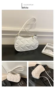 Detailed view of white quilted shoulder bag with triangular pattern and gold zipper pull