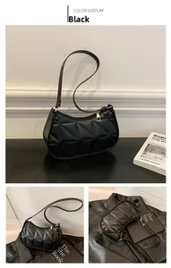 Detail of black quilted shoulder bag with geometric triangle texture and gold hardware