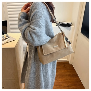 Détail du sac fourre-tout marron clair avec bandoulière chaîne et breloque en perles