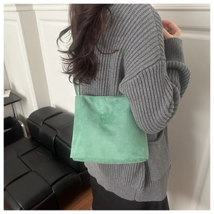Mint green suede bucket bag with embroidery styled with a grey knitted cardigan