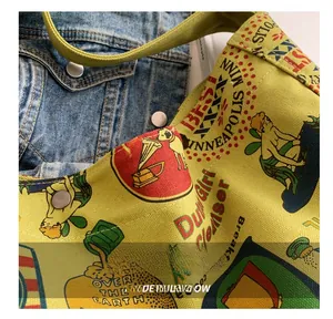 Detail shot of the precise stitching and retro graffiti print on a yellow canvas tote bag