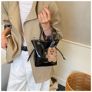 Détail du sac seau en cuir brillant avec bandoulière chaîne et breloque chien