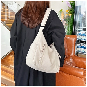 Detailansicht der cremeweißen Cordstruktur und des breiten Riemens einer Shopper-Tasche