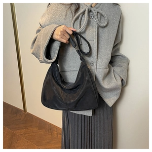 Detail of a large black crescent hobo bag made of durable nylon with a wide shoulder strap