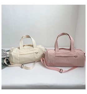 Detailed close-up of large-capacity nylon duffle bags in cream white and dusty pink colors