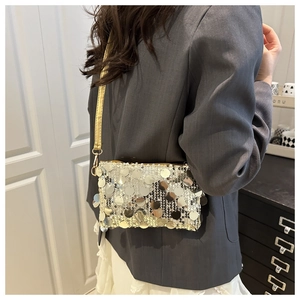 Detail of sequined shoulder bag showing gold and silver metallic texture on grey blazer