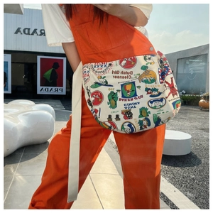 Detail of canvas crossbody bag featuring vintage graffiti prints and wide cotton strap