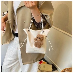 Détail du sac seau blanc à cordon avec poignée chaîne argentée et breloque ours