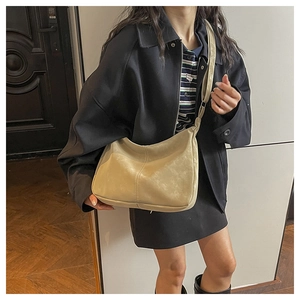 Detail of light beige large bucket bag with premium stitching and adjustable shoulder strap