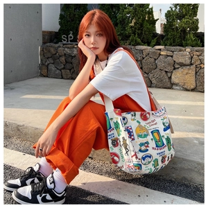 Detail of white canvas tote bag with retro cartoon graffiti and large capacity