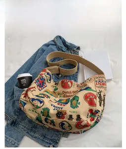 Detail of khaki canvas crossbody bag featuring vintage graffiti and wide adjustable strap