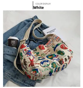 Detail of white canvas crossbody bag featuring colorful retro American graffiti art