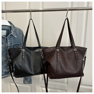 Detail of soft grain leather tote bags with silver star rivets and adjustable straps