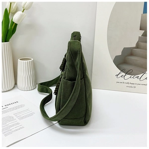 Detail einer dunkelgrünen Cord-Tasche mit Seitentasche und geflochtenem Reißverschluss