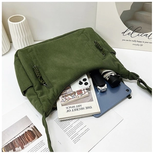 Detail der grünen Cord-Tasche mit geräumigem Innenfach und gewebtem Reißverschluss
