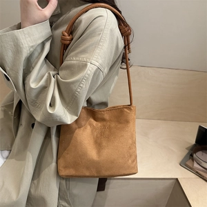 Brown matte suede bucket bag with long leather strap and fashion and classic embossing
