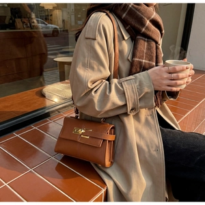 Vue détaillée du sac à bandoulière en cuir marron avec fermoir rotatif doré brillant
