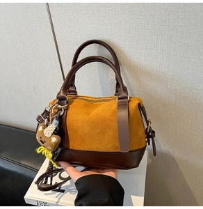 Détail du sac hobo contrasté en daim jaune avec pendentif ours en peluche