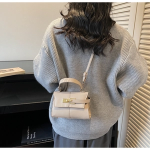 Sac à main en cuir beige porté par un mannequin pour montrer la taille et le style