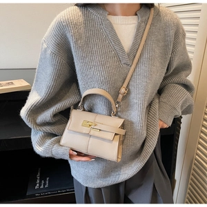 Détail du sac beige en cuir grainé avec fermoir métallique et bandoulière amovible