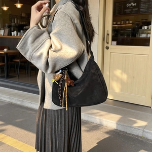 Large black crescent hobo bag with cute bear charm and tassel details for women