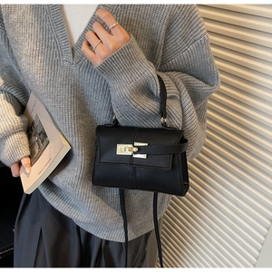 Sac à main élégant en cuir litchi noir avec boucle dorée en situation réelle
